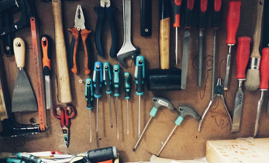 Hand tools hung on a wooden shop wall — photo from the Alvarado / Villa live site